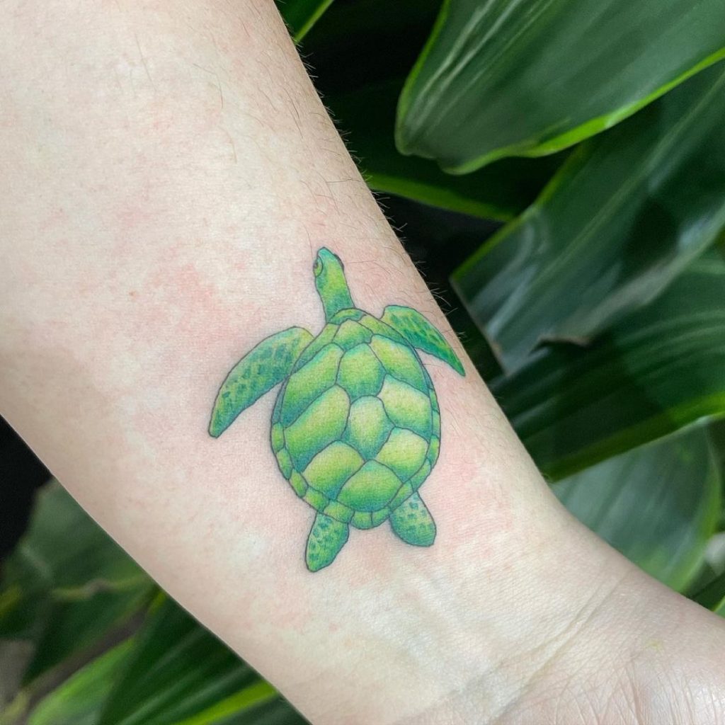 A picture of a loggerhead turtle tattoo with a bright green color.