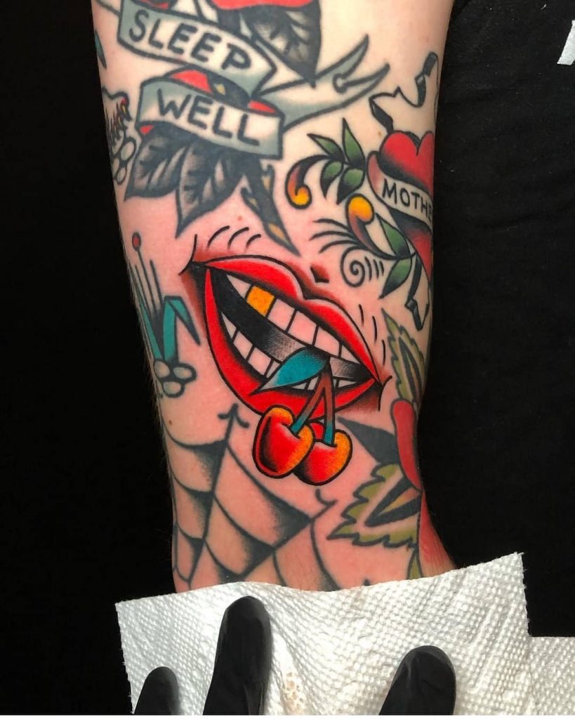A smiling tattoo with a gold tooth