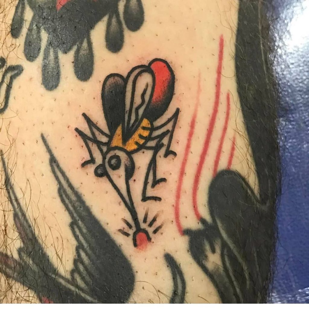 A fly tattoo on an arm.