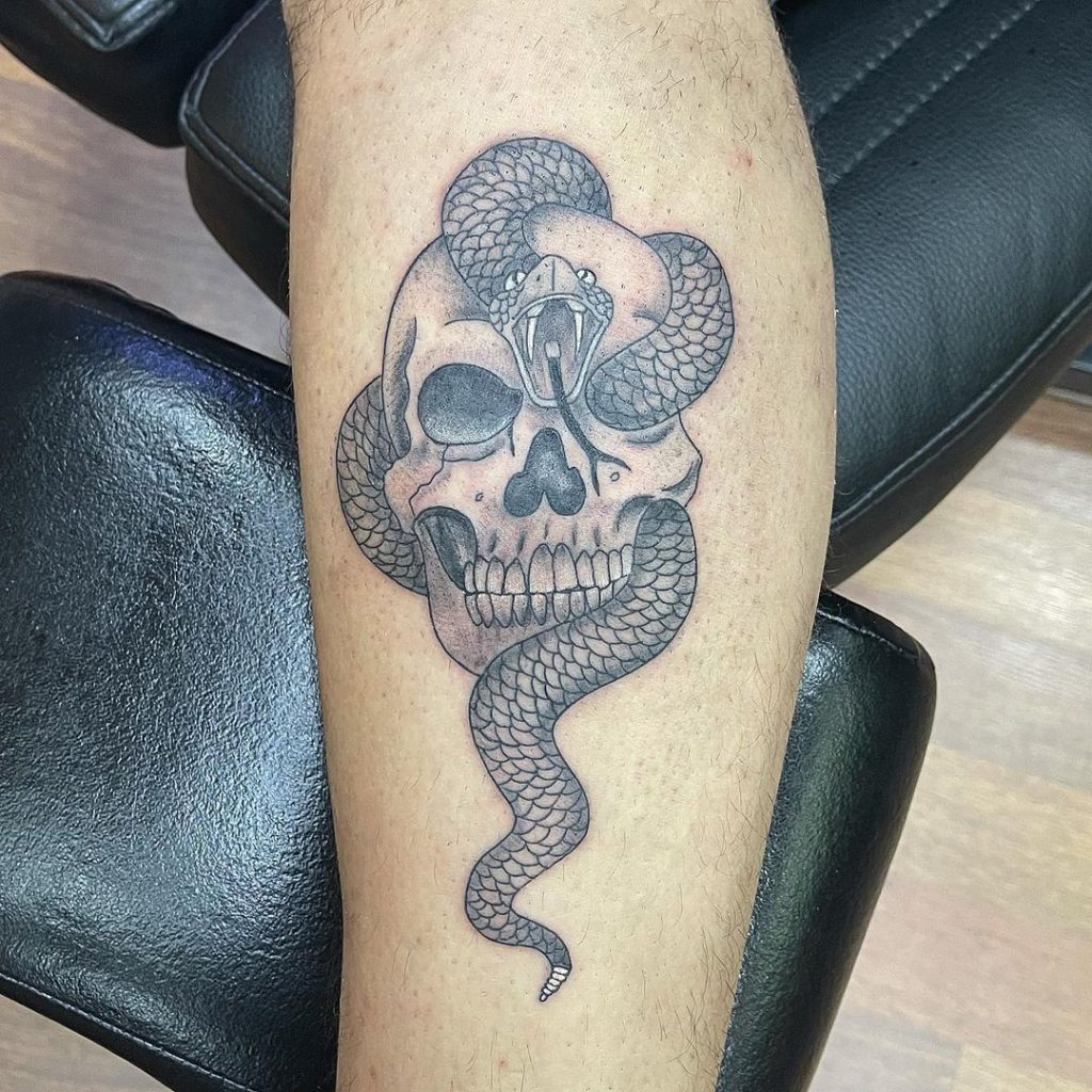A skull with a snake small tattoo idea