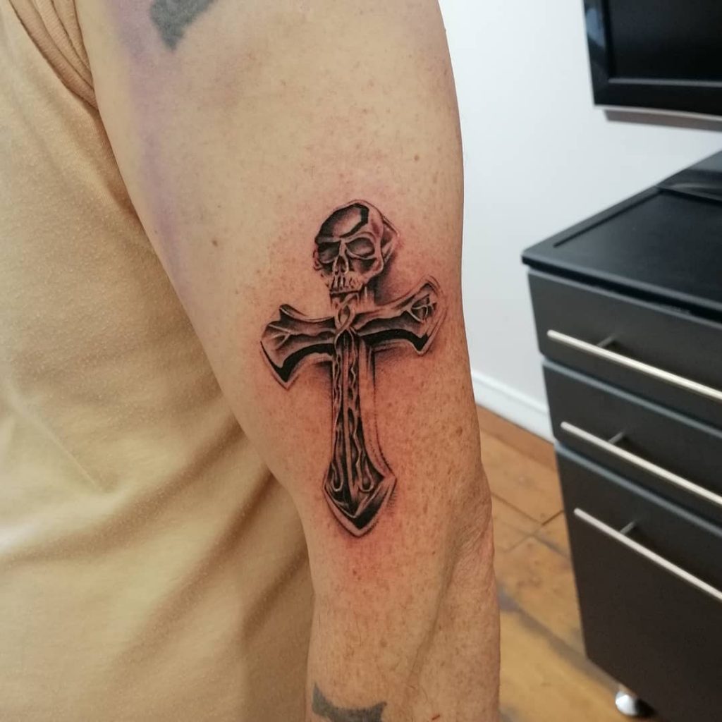 Crosses embodied by small skull tattoos.