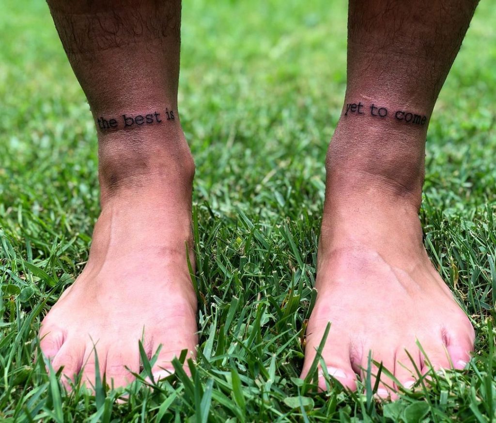 An ankle writing small leg tattoo