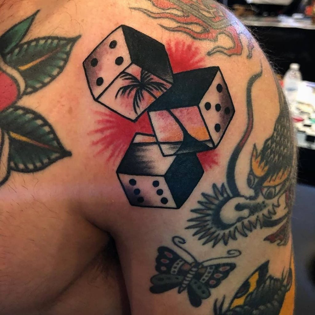 A dice small gap tattoo with sunset pictured on it.