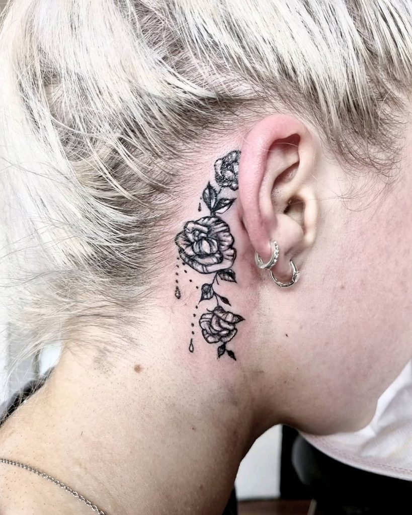 Monochrome roses as behind the ear tattoos