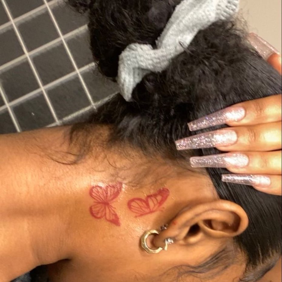 Red butterfly tattoo behind ear