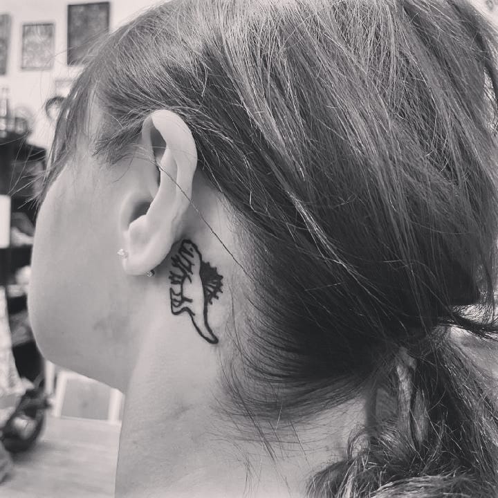 Dinosaurs as behind the ear tattoos