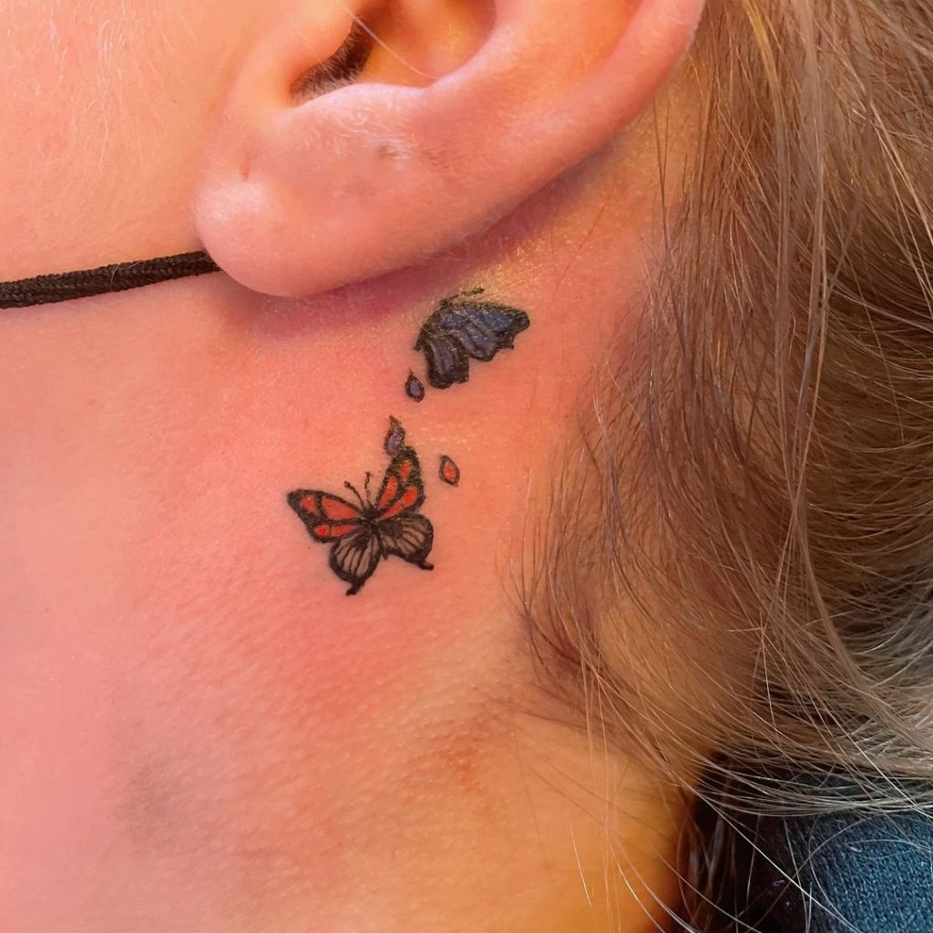 Colorful butterfly tattoo behind ear